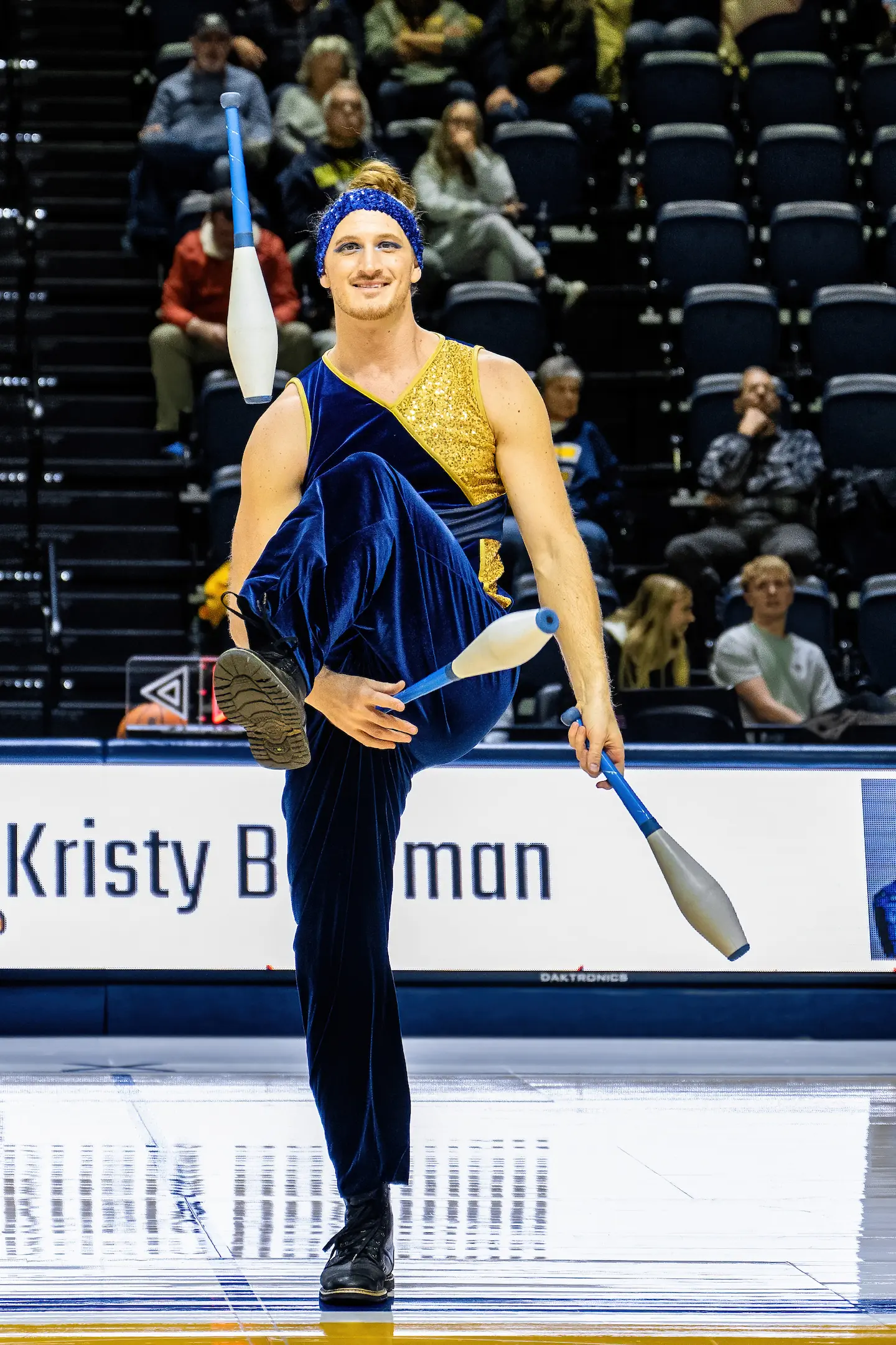 Dazzling juggler throwing pins under his legs at UTC college basketball halftime show