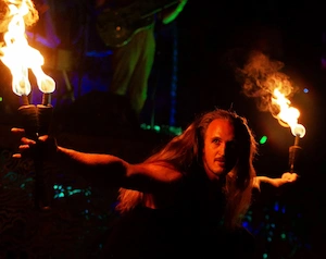 Fire juggler dramatically holding flaming torches