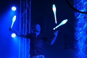 Juggler with LED clubs on stage