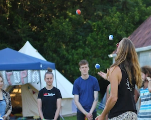 Juggler teaching a group of interested people how to juggle balls